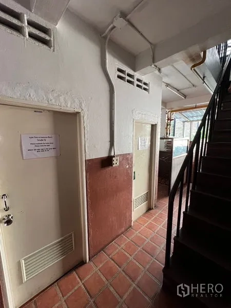 零售空间 出租或出售在Khlong Toei, Bangkok - 楼梯与服务走廊，铺砖地面和多扇房门。
