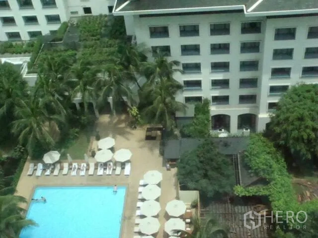 คอนโด ให้เช่าในPathum Wan, Bangkok - มุมสูงสระว่ายน้ำคอนโด พร้อมเก้าอี้อาบแดดและต้นปาล์มในย่านปทุมวัน