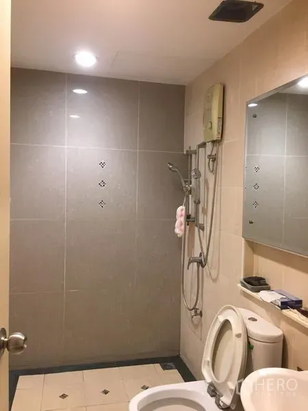 联排别墅 出租或出售在Wang Thonglang, Bangkok - 浴室采用中性色瓷砖，设步入式淋浴、电热水器、坐便和墙面镜。