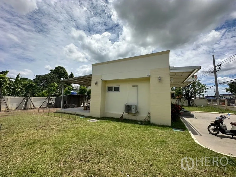 สำนักงาน ให้เช่าในPathum Thani - ด้านข้างอาคารสำนักงาน พื้นที่สนามหญ้า ทางรถเข้า และชุดแอร์