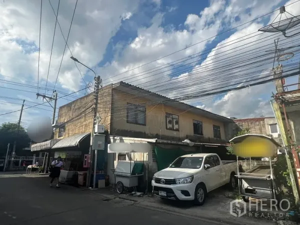 ที่ดิน ให้เช่าหรือขายในPhra Khanong, Bangkok - ซอยด้านหลังเห็นอาคารเตี้ยพร้อมกันสาด รถกระบะจอด และสายไฟจำนวนมาก.