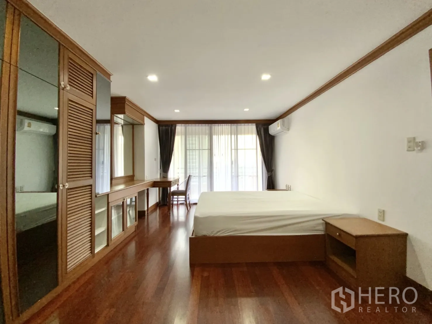 คอนโด ให้เช่าในWatthana, Bangkok - ห้องนอนเปิดออกสู่ระเบียง มีตู้บิลท์อิน โต๊ะทำงาน และพื้นไม้