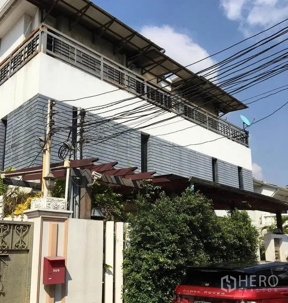 Detached House for rent in Khlong Toei, Bangkok - Contemporary multi-storey house exterior with balconies and gated entry.