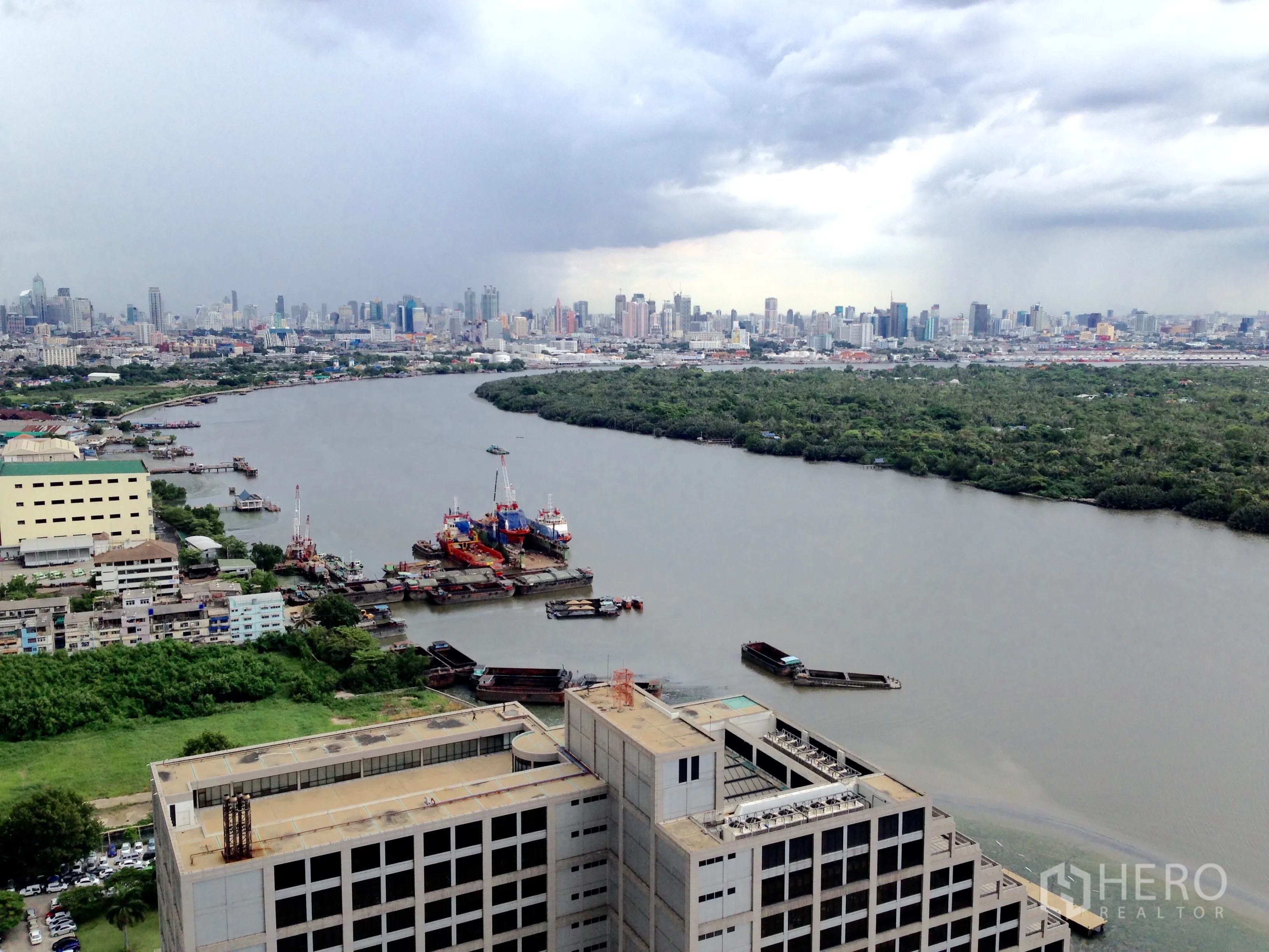 公寓 for sale in Yan Nawa, Bangkok - 高楼层河景与城市天际线，临近船只作业的水岸。