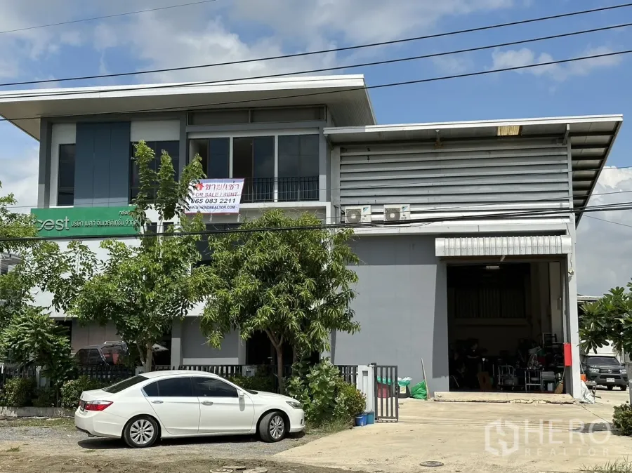 工厂 出租或出售在Pathum Thani - 临街迷你工厂外观，带两层办公室和大型卷闸门，前方停车位。