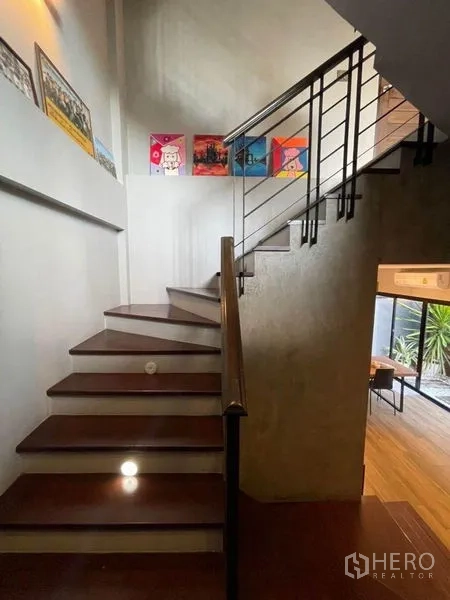 ทาวน์เฮาส์ ขายในBang Phli, Samut Prakan - บันไดขั้นไม้ ราวเหล็ก พร้อมภาพงานศิลป์ประดับผนัง.