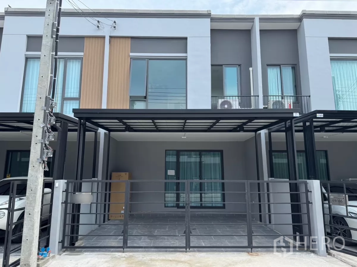 Townhouse for rent in Bang Phli, Samut Prakan - Modern two-storey townhouse exterior in Bang Phli with a gated covered double carport.