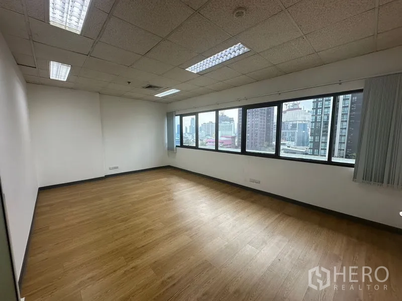 办公空间 出租在Watthana, Bangkok - 转角办公室，宽幅窗户引入自然光与天际线景观。