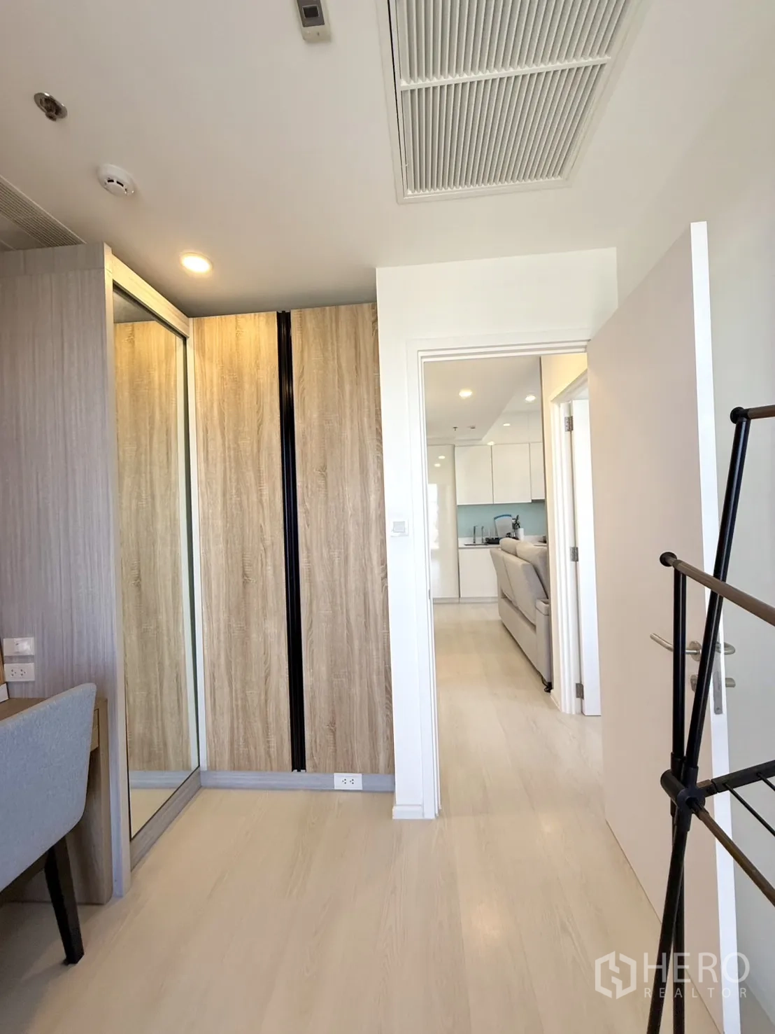 Condominium for sale in Chatuchak, Bangkok - Hallway from second bedroom with wardrobes leading to the living area.