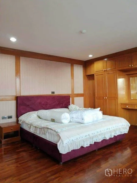 Condominium for rent in Watthana, Bangkok - Master bedroom with king bed, built-in wardrobes and hardwood floors.
