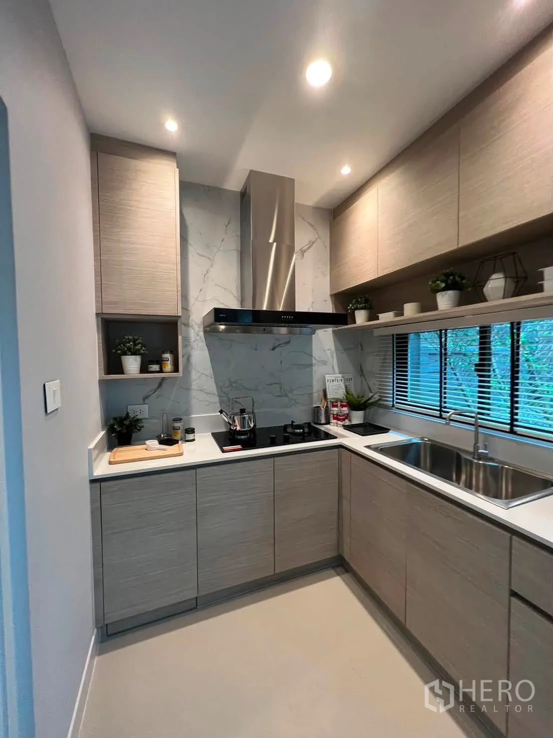 Townhouse for rent in Saphan Sung, Bangkok - U-shaped kitchen with upper cabinets, range hood, and a window over the sink.