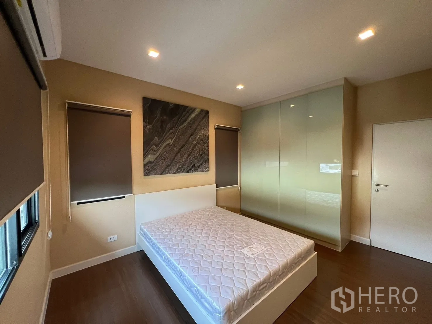 Detached House for rent in Bang Phli, Samut Prakan - Secondary bedroom showing glossy built-in wardrobe doors and dual blackout roller blinds.