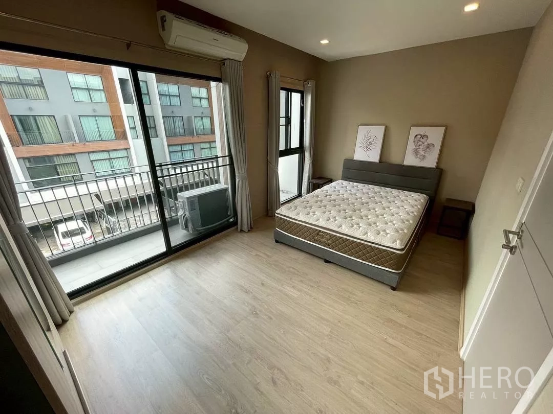 ทาวน์เฮาส์ ให้เช่าในSuan Luang, Bangkok - ห้องนอนกว้างพร้อมประตูกระจกบานเลื่อนออกสู่ระเบียง มองเห็นวิวชุมชน.