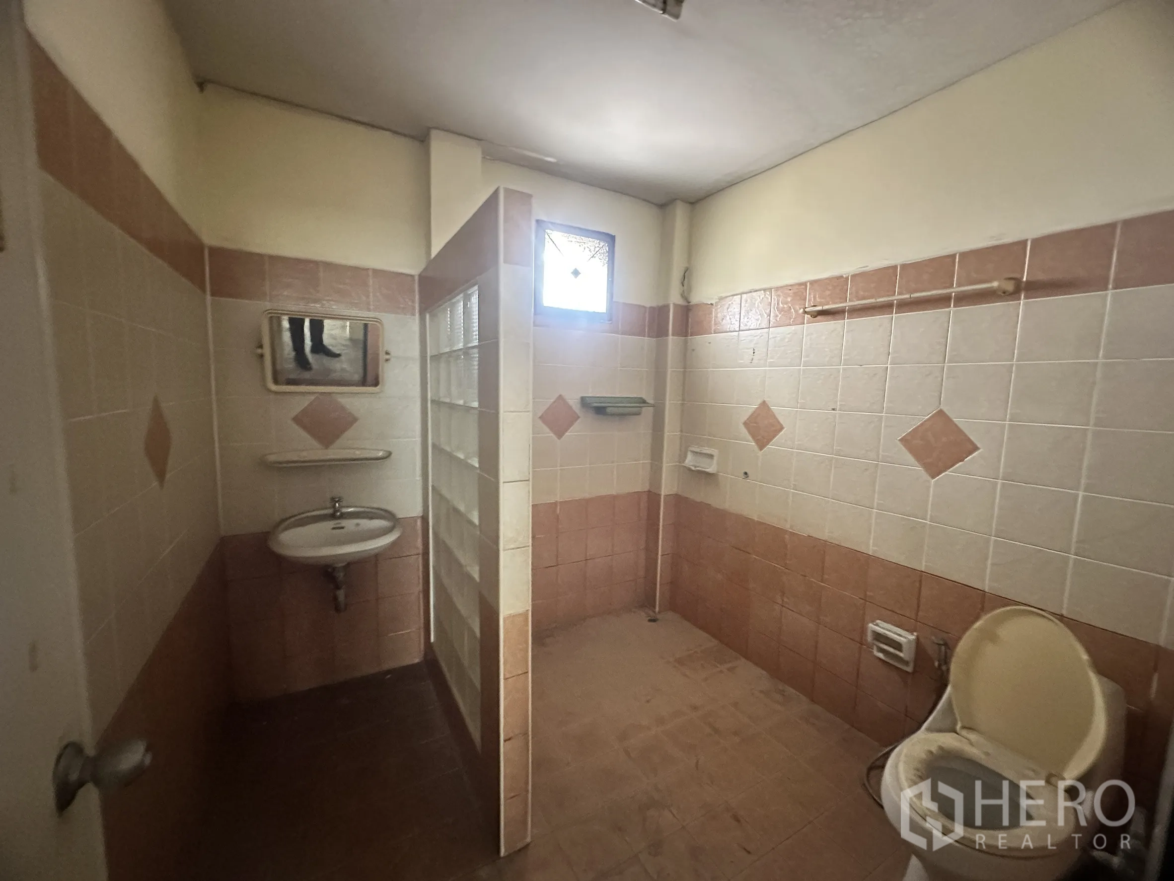 Factory for sale in Bang Bua Thong, Nonthaburi - Bathroom with tiled walls, glass-block shower partition, and toilet.