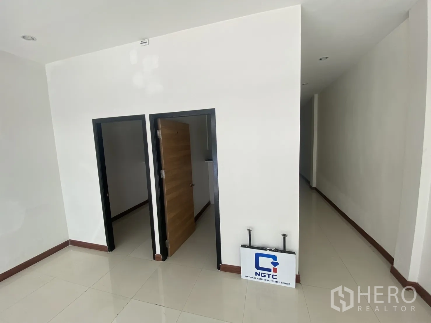Shophouse for rent in Bang Rak, Bangkok - Ground-floor interior with glossy tiles, white walls, and two doorways.
