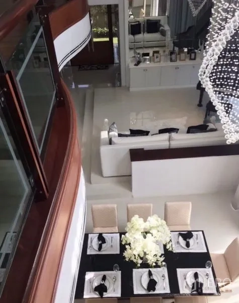 Detached House for sale in Saphan Sung, Bangkok - Aerial view of open-plan dining and living space with white sofas and a statement chandelier.