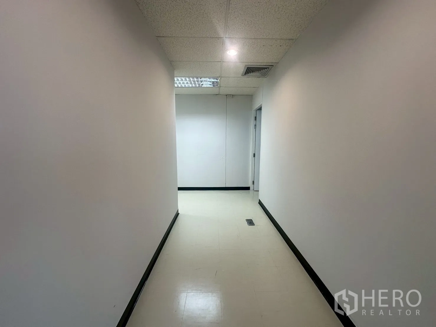 สำนักงาน ให้เช่า - ทางเดินภายในสะอาดตา ผนังสีขาว ไฟดาวน์ไลท์ และประตูเข้าสู่ห้องสำนักงาน