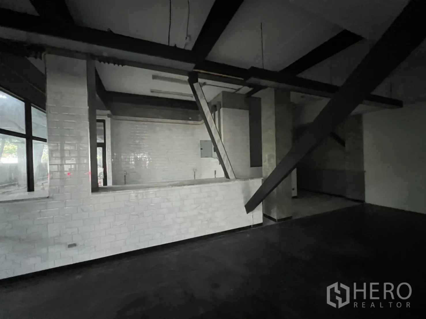 零售空间 出租在Ratchathewi, Bangkok - 店内白砖吧台、外露梁与斜向支撑