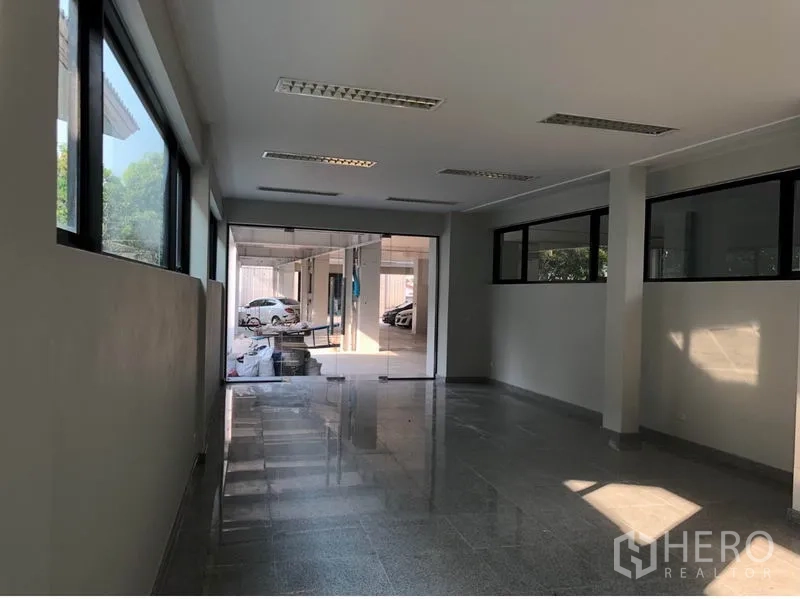 办公空间 出租在Khlong Toei, Bangkok - 明亮走道式办公区，玻璃隔断，通向有顶停车区。