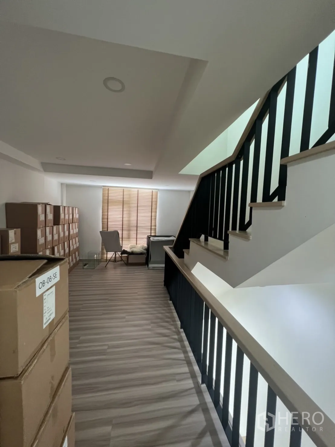 Home Office for rent or sale in Phra Khanong, Bangkok - Upper-floor corridor with boxes, wood flooring and stair railing.