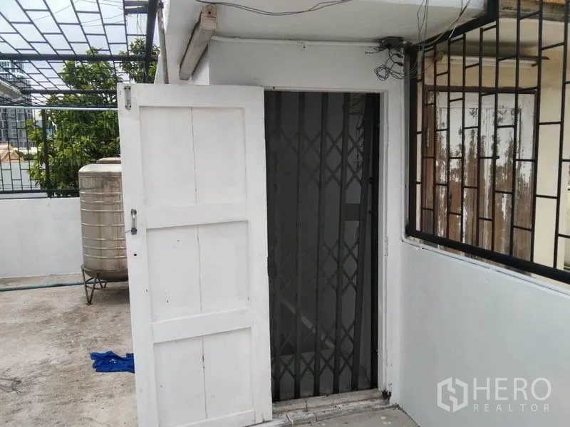 อาคารพาณิชย์ ให้เช่าในWatthana, Bangkok - ทางเข้าดาดฟ้ามีพับลูกกรงเหล็กและประตูไม้สีขาว.