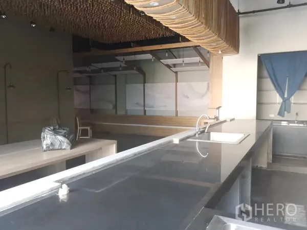 零售空间 出租在Khlong Toei, Bangkok - 黑色长操作台带水槽，面向高挑空间与特色天花装饰