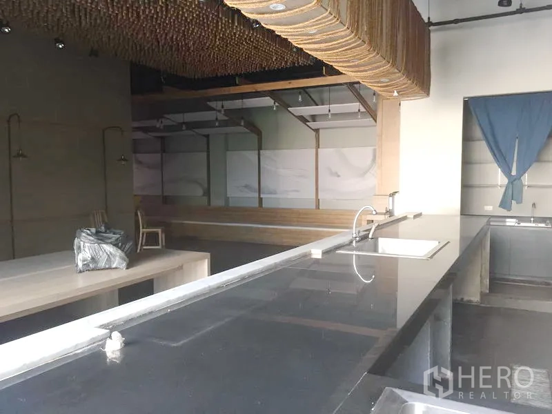 零售空间 出租在Khlong Toei, Bangkok - 黑色长操作台带水槽，面向高挑空间与特色天花装饰