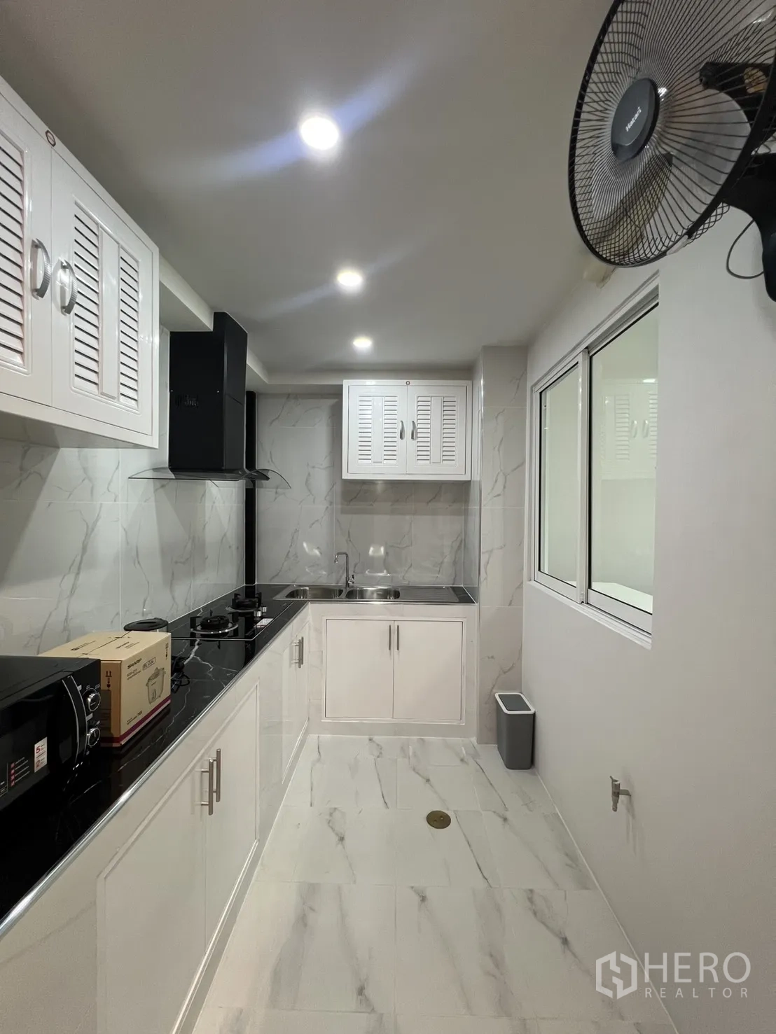 Townhouse for rent in Bang Phli, Samut Prakan - White built-in kitchen with cooktop, range hood and double sink.