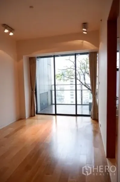 公寓 出售在Sathon, Bangkok - 明亮卧室，玻璃门通往可观景的阳台。