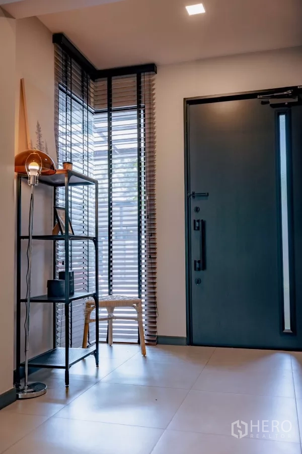 独立式住宅 出租或出售在Bang Phli, Samut Prakan - 入户玄关，深色大门与转角落地窗百叶。