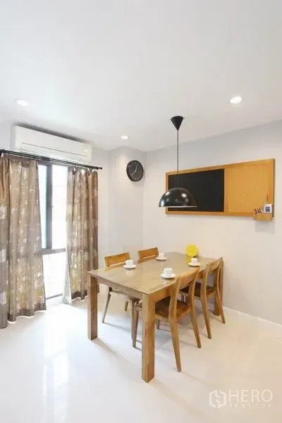 ทาวน์เฮาส์ ให้เช่าในPhra Khanong, Bangkok - มุมทานอาหารสว่าง โต๊ะไม้ โคมแขวน และหน้าต่างพร้อมผ้าม่าน