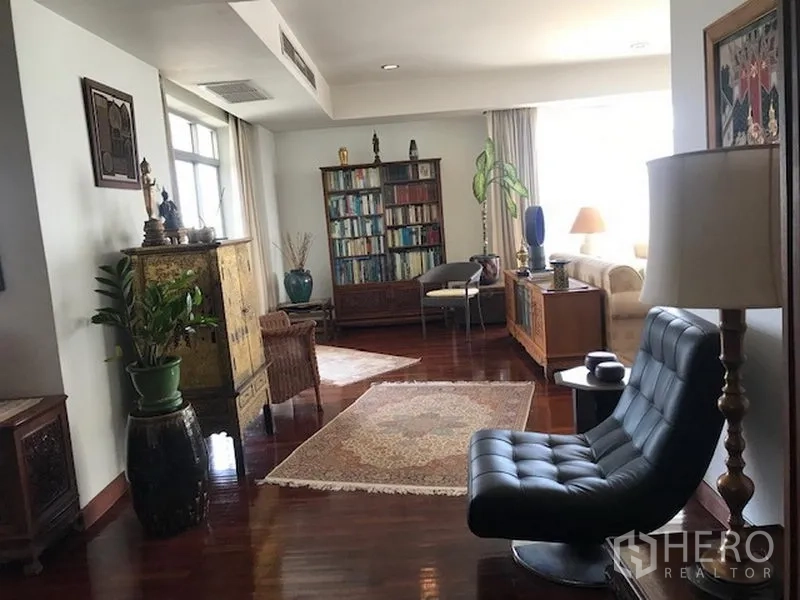 公寓 出租或出售在Watthana, Bangkok - 宽敞客厅，实木地板、书柜与休闲沙发。