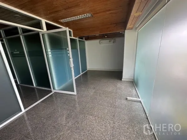Office Space for rent - Corridor-style meeting zone with multiple frosted glass doors, timber ceiling and glossy floor.