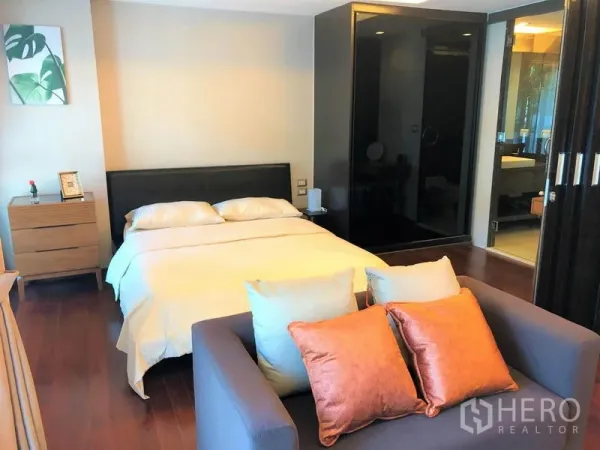 Condominium for rent in Watthana, Bangkok - Bright bedroom with queen bed, two-seat sofa and sliding-door access to the bathroom.