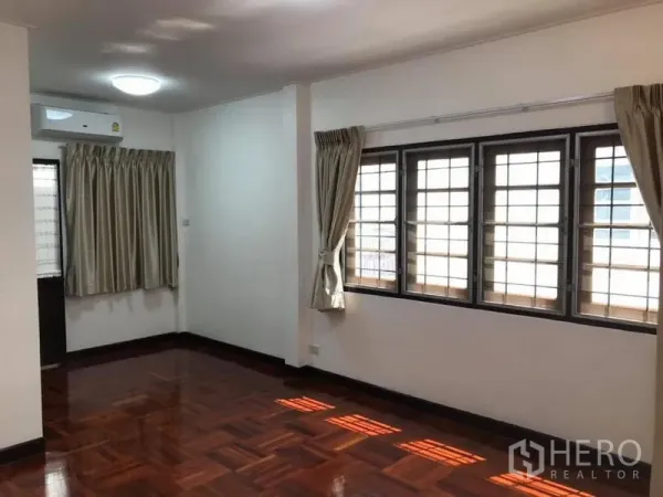 Detached House for rent in Khlong Toei, Bangkok - Bright room with parquet wood flooring, multiple barred windows and air conditioner