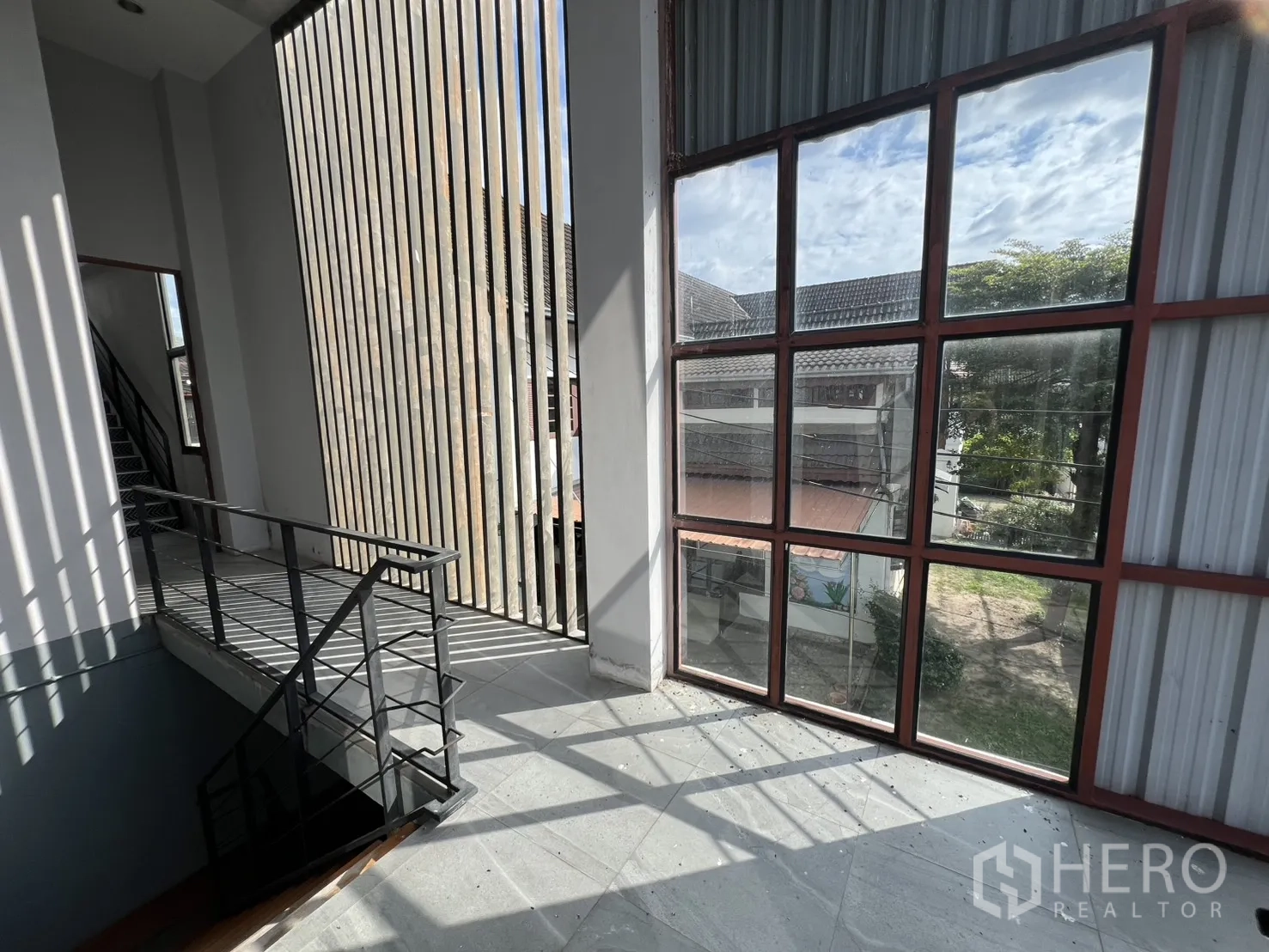 Home Office for rent in Mueang Nonthaburi, Nonthaburi - Stair hall with slatted screen and grid window casting shadows.