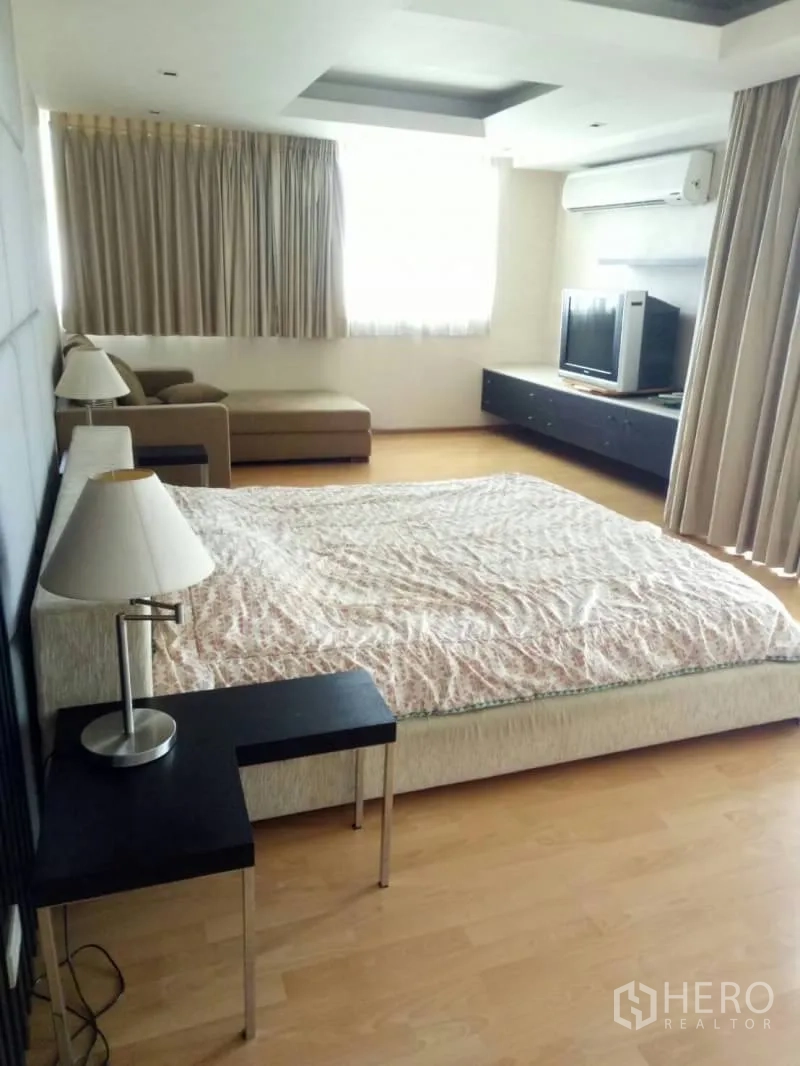 Condominium for rent in Watthana, Bangkok - Bright bedroom with king-size bed, bedside tables, chaise sofa, TV cabinet, and large windows.