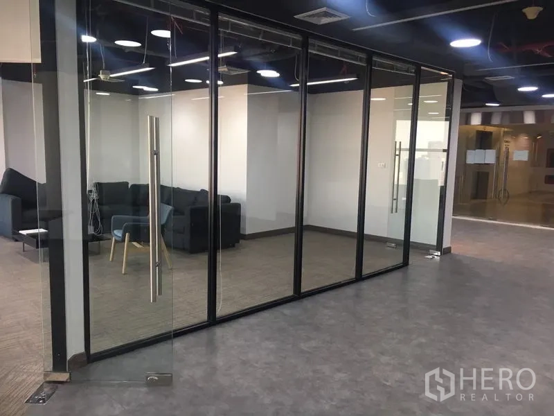 Office Space for rent in Sathon, Bangkok - Entrance to a glass-fronted office suite with clear doors and lounge area inside.