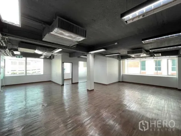 Office Space for rent in Ratchathewi, Bangkok - Bright corner office area with large windows and enclosed glass rooms.