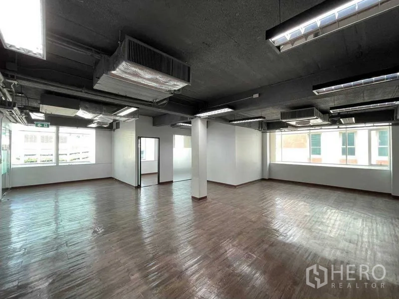 Office Space for rent in Ratchathewi, Bangkok - Bright corner office area with large windows and enclosed glass rooms.