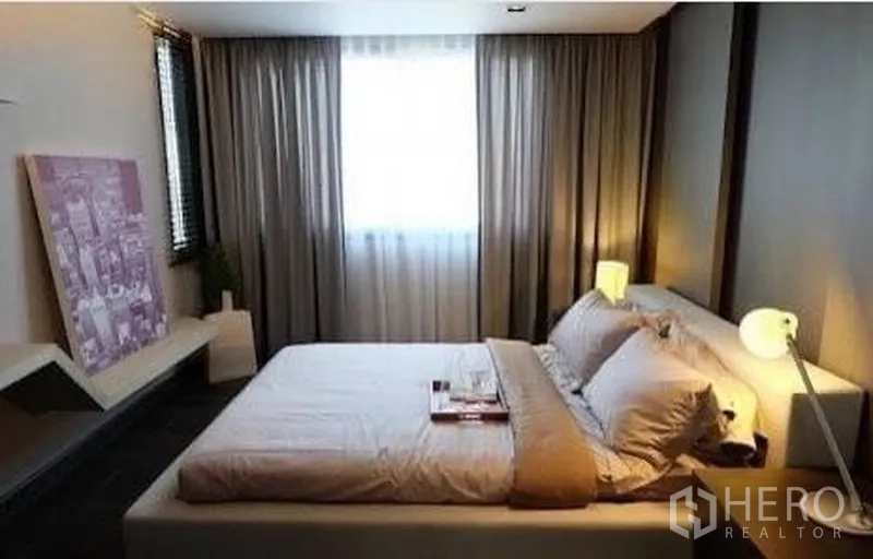 Townhouse for rent in Watthana, Bangkok - Cozy bedroom with soft lighting, drapery and built-in shelf.