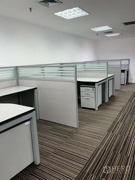 Office Space for rent - Row of modern workstations with frosted glass partitions and storage drawers.