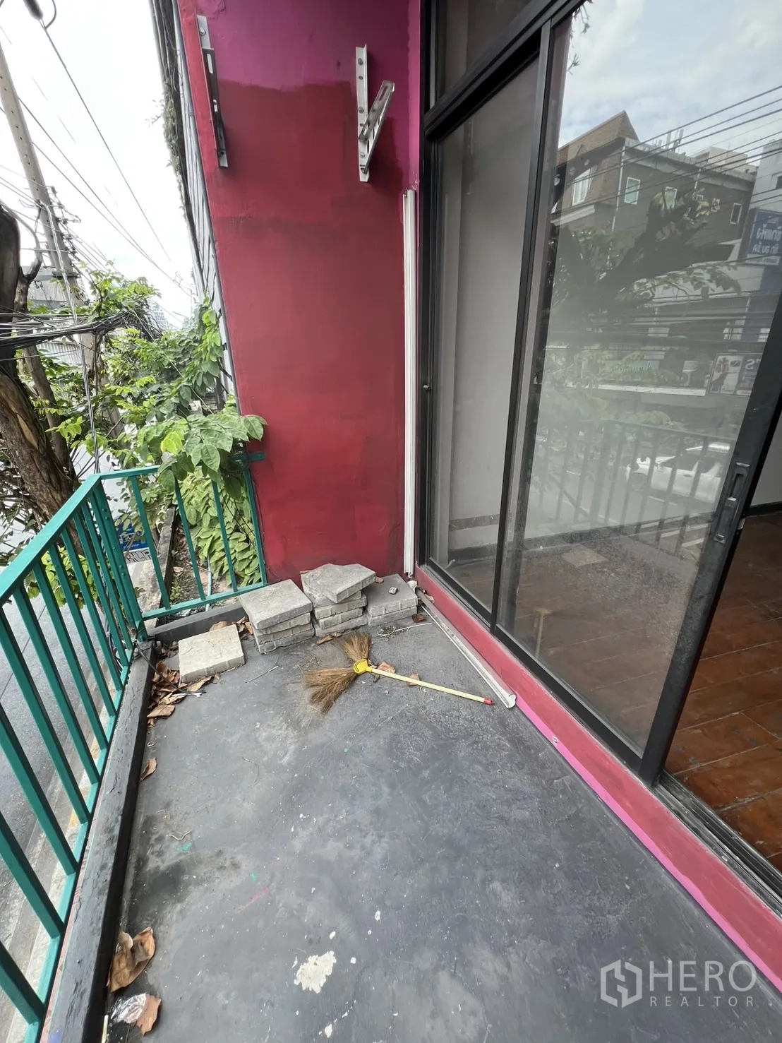 店屋 出租在Watthana, Bangkok - 小前阳台，绿色栏杆，俯瞰Ekkamai街景。