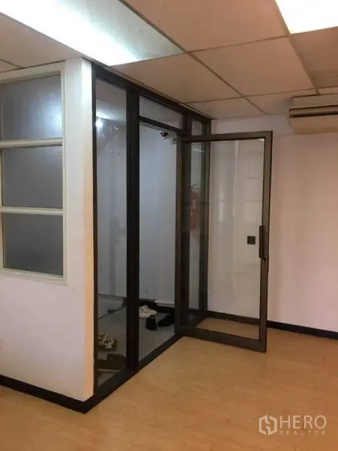 Office Space for rent in Bang Na, Bangkok - Glass-partitioned meeting room with swing door, light wood flooring and drop ceiling lighting.