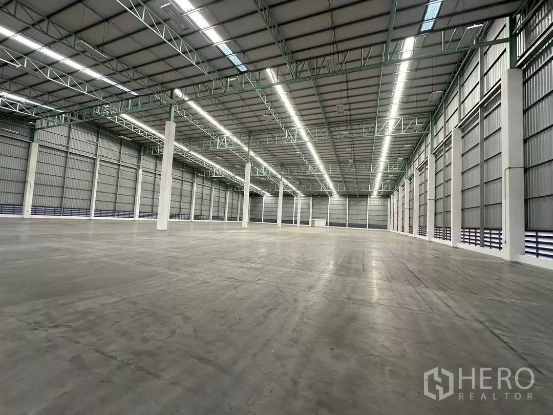 工厂 出租在Si Racha, Chon Buri - 无柱厂房大厅，金属保温墙体、白色立柱与明亮照明。