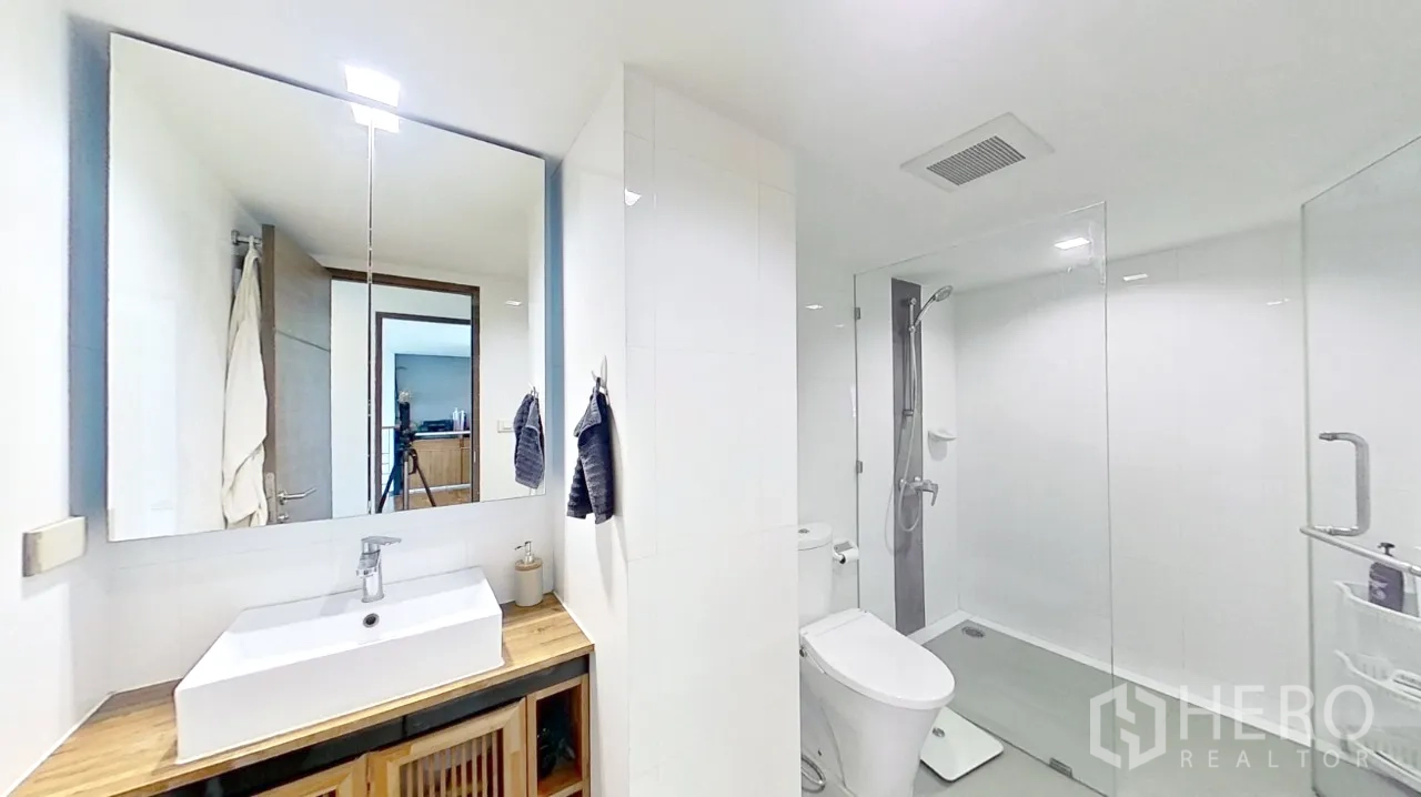 คอนโด for rent in Watthana, Bangkok - ห้องน้ำโทนขาวสะอาดพร้อมตู้กระจกกั้นอาบน้ำและเคาน์เตอร์ล้างหน้า