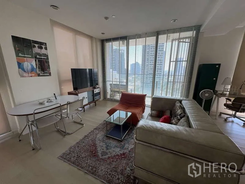 Condominium for rent - Living room with sofa, rug, TV and balcony screened by vertical blinds.
