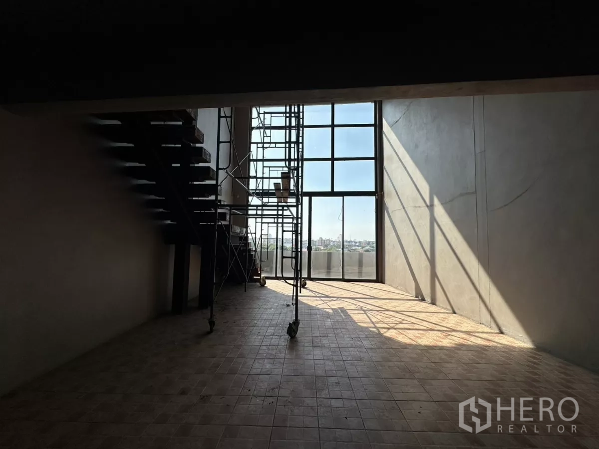 店屋 出租在Bang Na, Bangkok - 双层玻璃墙前的脚手架在地面投下阴影。