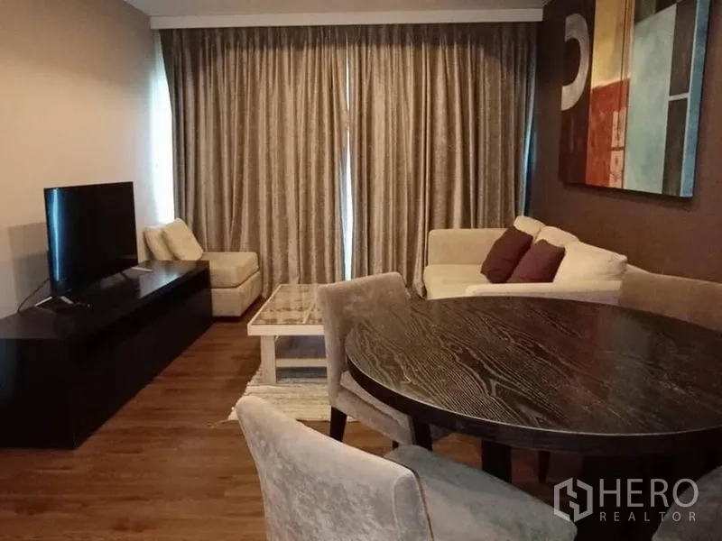 公寓 出租在Sathon, Bangkok - 现代风客厅，配沙发、圆形餐桌、电视柜与落地窗帘。