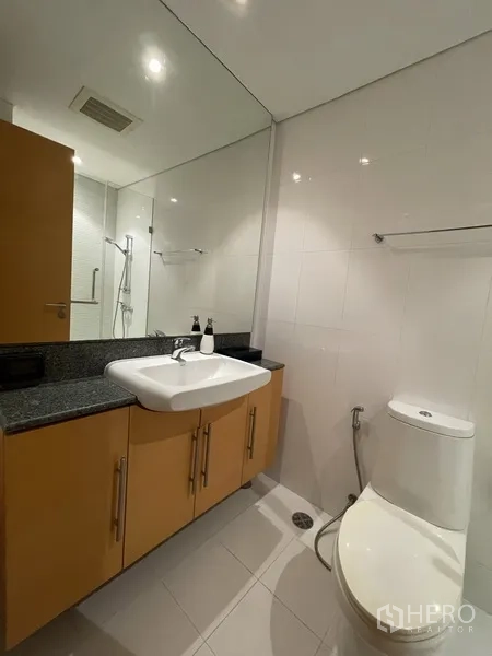 คอนโด ให้เช่าหรือขายในWatthana, Bangkok - ห้องน้ำที่สอง ผนังกระเบื้องสีขาว เคาน์เตอร์หินแกรนิต อ่างล้างหน้า โถสุขภัณฑ์ และโซนอาบน้ำ.